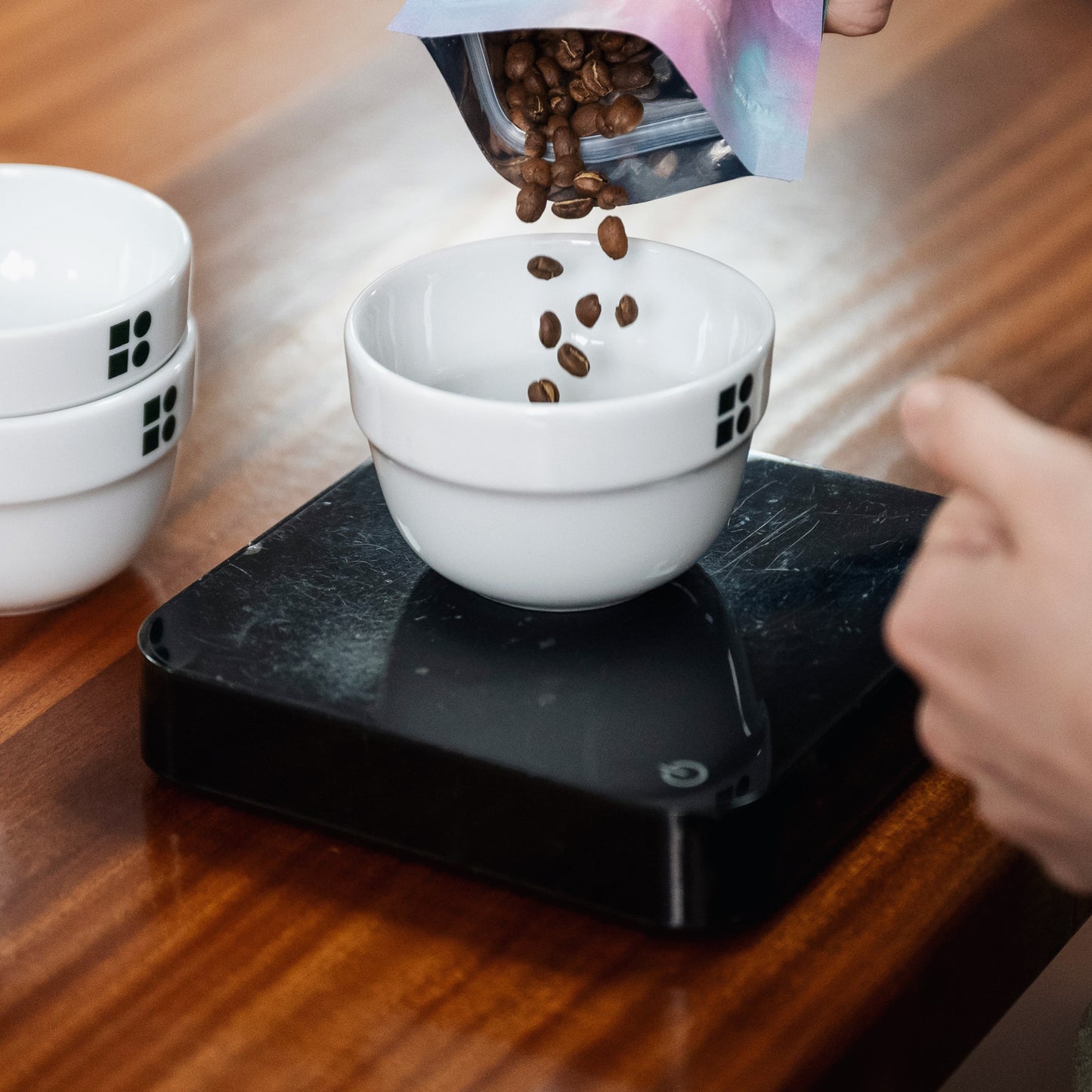 beans being poured into a cupping bowl ontop of the acaia scales 