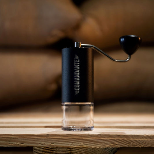 Commandante Hand Grinder MK4 against green bean coffee bags