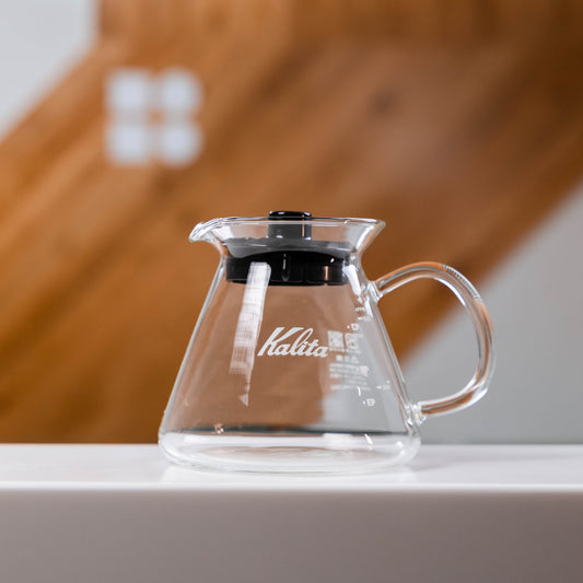 glass kalita coffee server with a black lid and glass handle 
