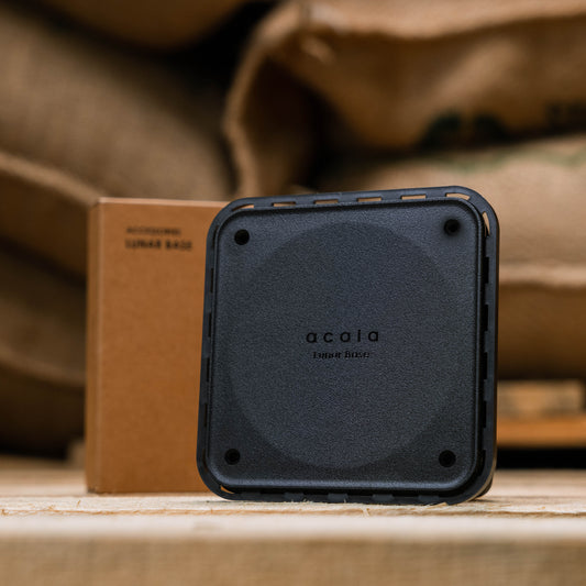 black metal base for scales displayed in front of green coffee bean bags 